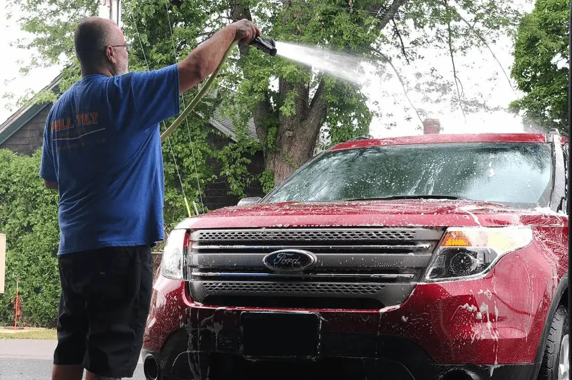 A technician inspecting a chipped windshield on a vehicle at Full Tilt Auto Body